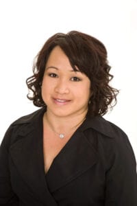 A woman with brown hair wearing a black shirt.