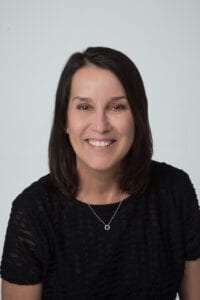 A woman in black shirt smiling for the camera.