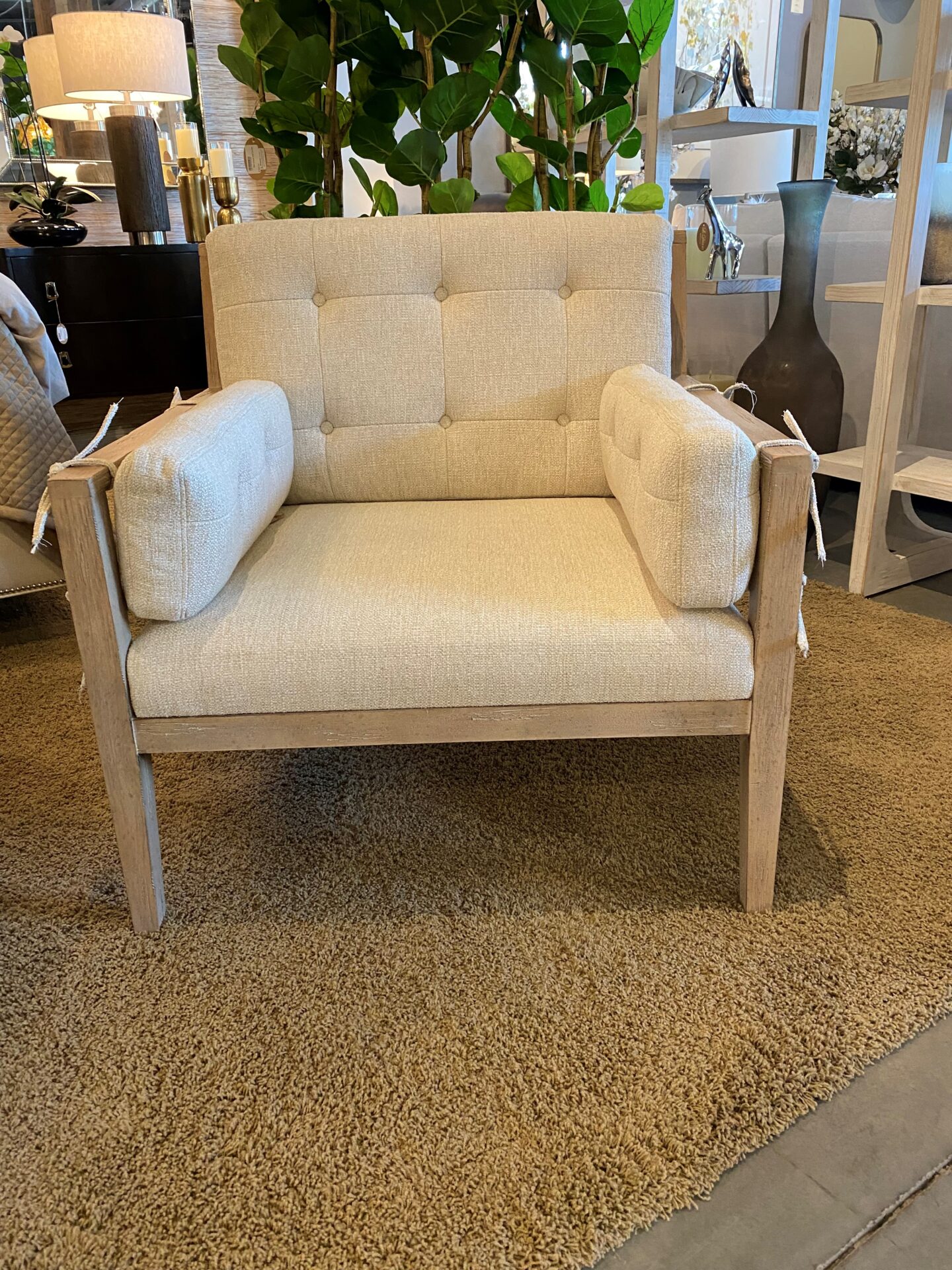 A white chair with a beige cushion on the back.