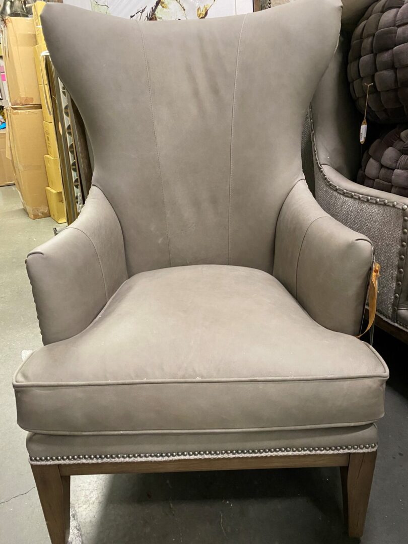 A chair with a beige fabric and wooden frame.