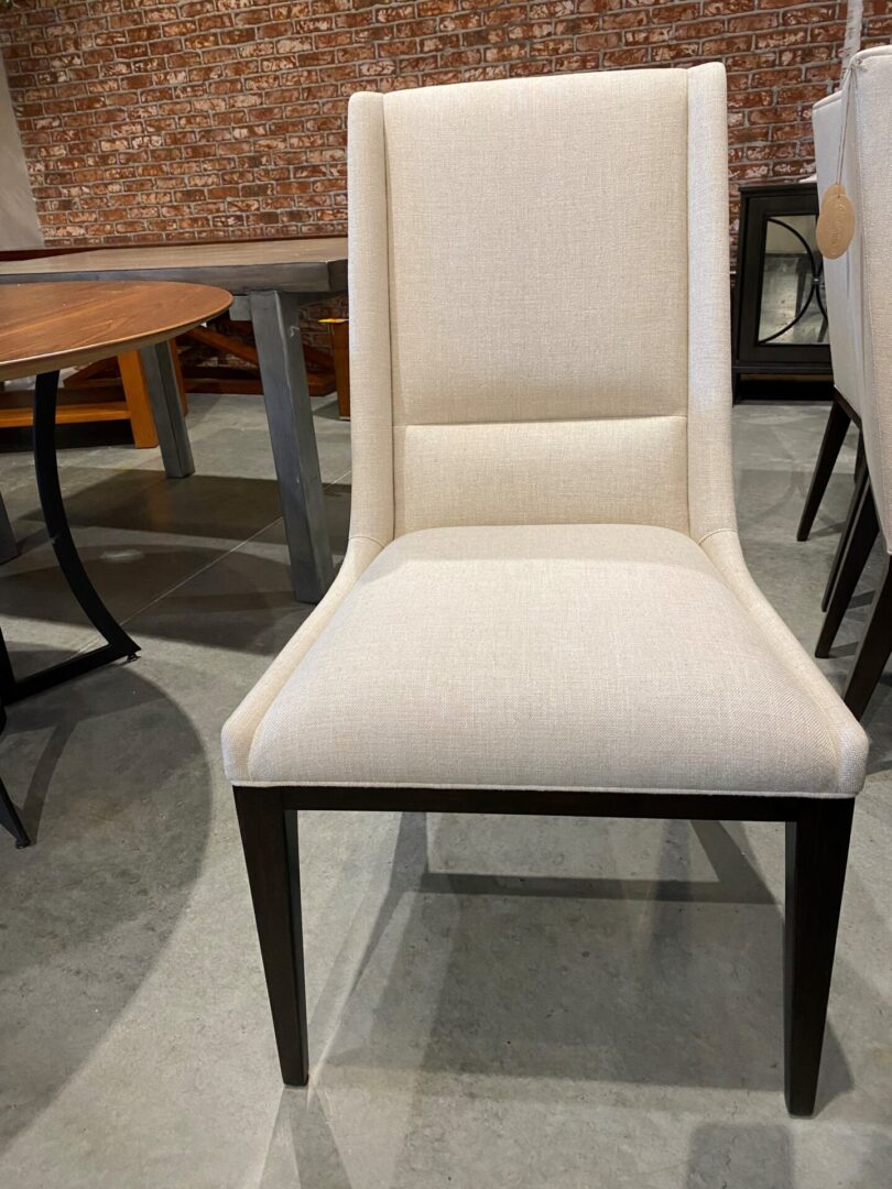 A white chair with black legs and back.