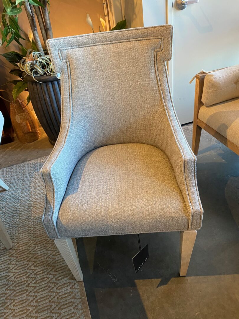 A chair with a white frame and beige fabric.