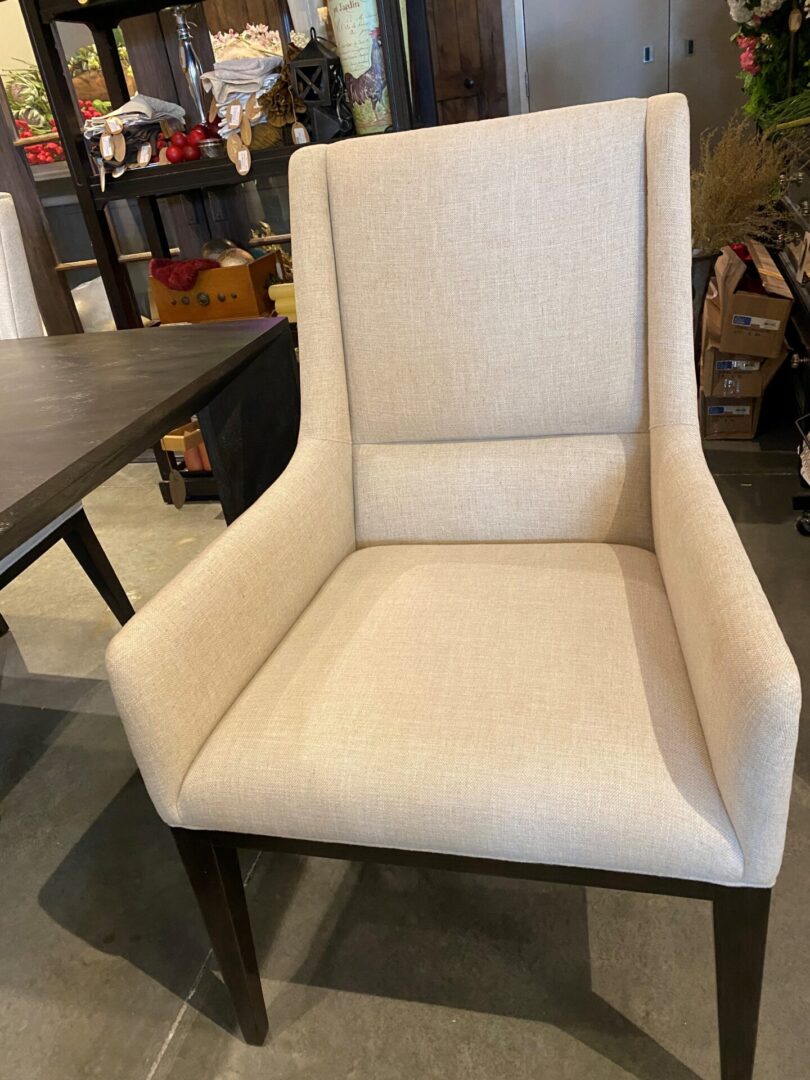 A white chair with a wooden frame and fabric seat.