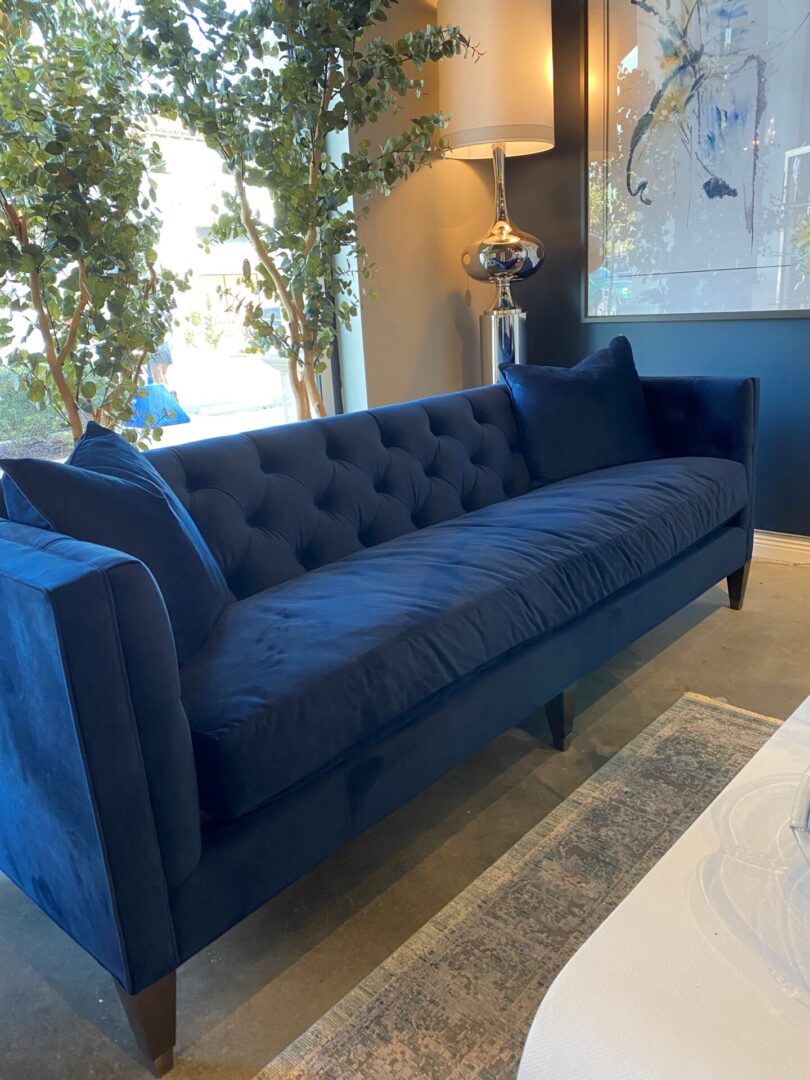 A blue couch sitting in front of a window.